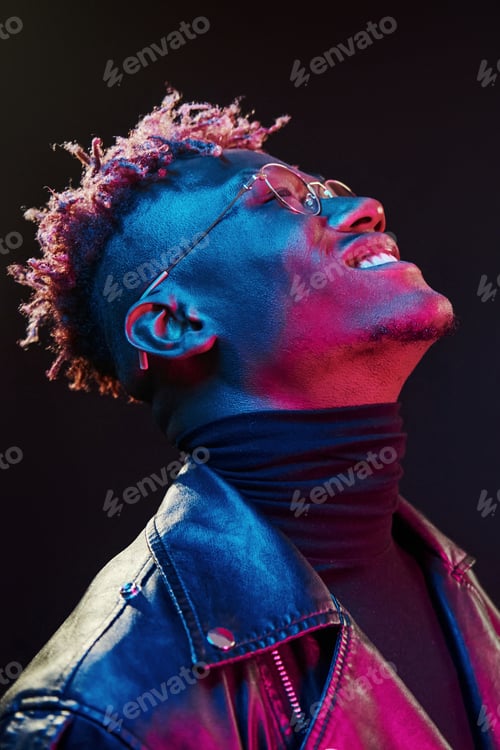 Preview: In glasses. Futuristic neon lighting. Young african american man in the studio