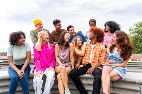 Preview: Happy playful multiethnic group of young friends bonding outdoors