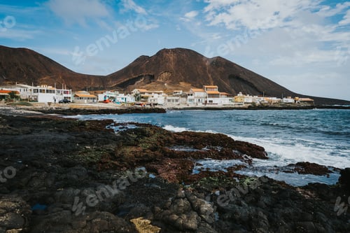 Preview: Calhau village on ocean coast in front of red colored volcanic crater. Cape Verde - Sao Vicente
