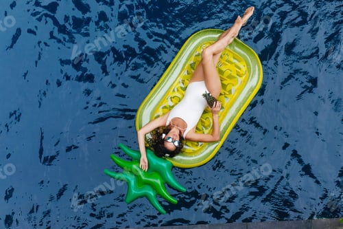 Preview: Wonderful young lady swimming in pool with pineapple. Outdoor photo of ecstatic graceful girl havin