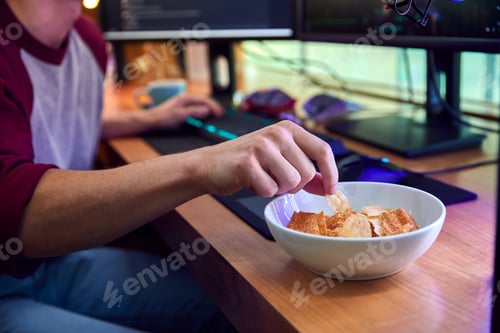 Preview: Close Up Of Man Gaming At Home Eating Potato Chips Sitting At Desk With Monitors