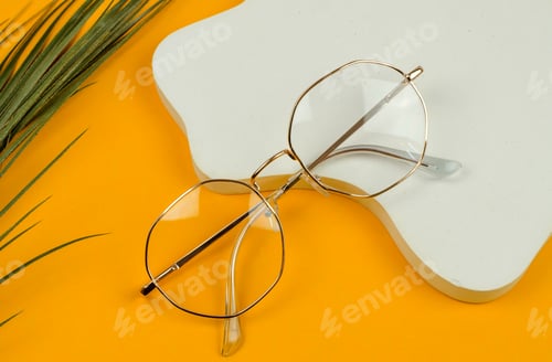 Preview: Stylish women's glasses in a gold-colored frame on a colored background