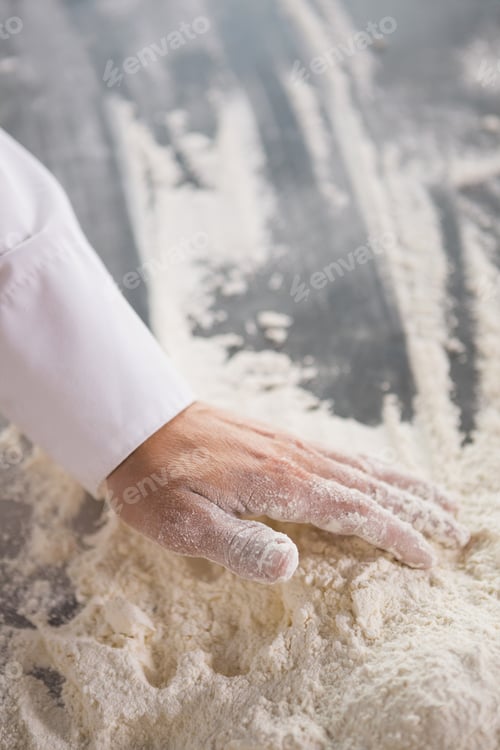Preview: Close up of baker preparing dough in the kitchen of the bakery