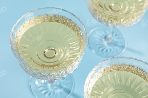Preview: Glasses of expensive white wine on light blue background, above view