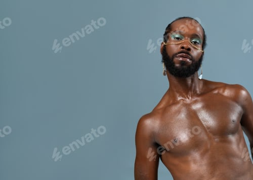 Preview: Black gay man with makeup and gold accessory on face
