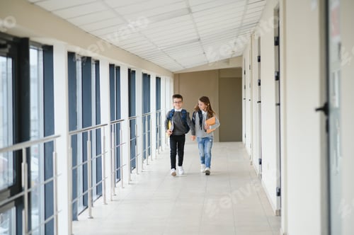 Preview: Portrait of smiling school kids in school corridor with books