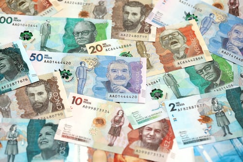 Preview: Colombian pesos money bills banknotes lies in big pile on table close up. Finances and business