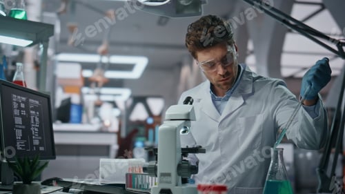 Preview: Young microbiologist experimenting medicines in clinic laboratory close up.