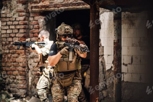 Preview: Air soft teammates in action at abandoned demolished building.