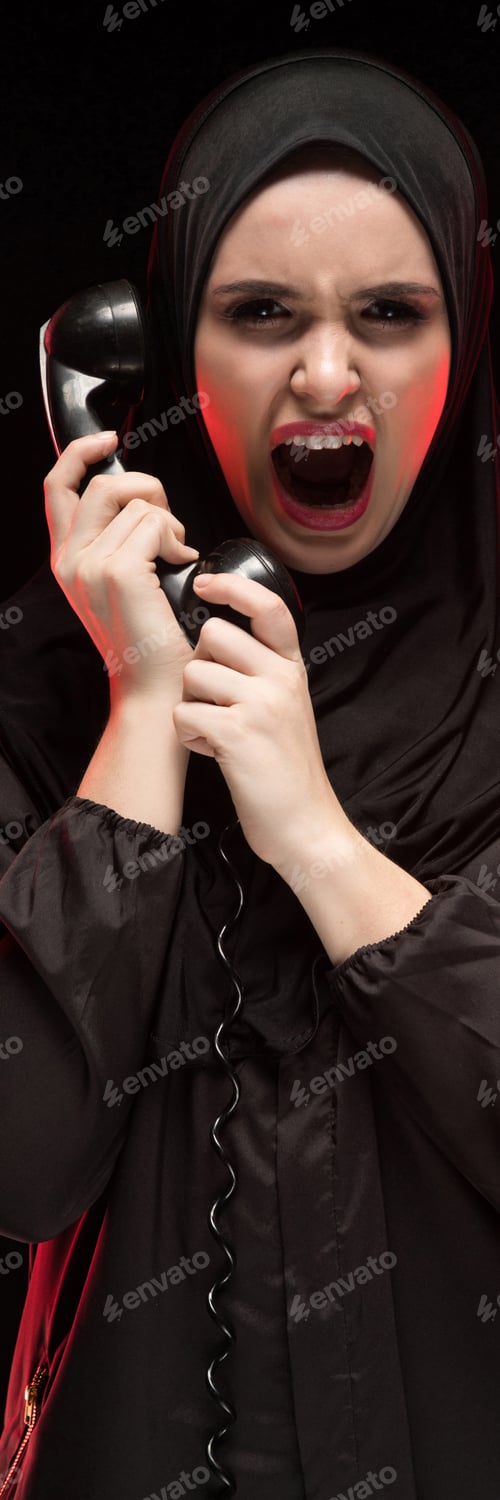 Preview: Portrait of beautiful serious scared young muslim woman wearing black hijab screaming calling for