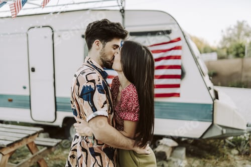 Preview: Beautiful Spanish couple kissing on background of the US flag - US Independence day