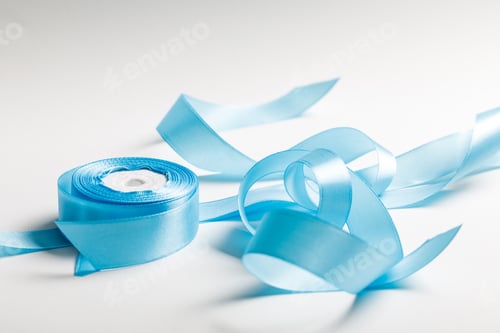 Preview: curved blue satin ribbon with spool on grey background