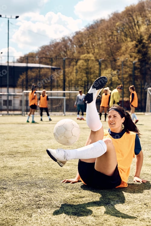 Preview: Female soccer player exercising with ball during sports training at the stadium.