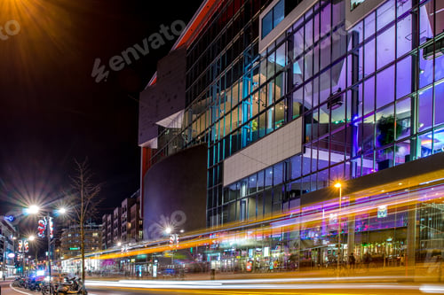 Preview: Low shot angle of buildings with window and glass pane reflecting lights from the street at night