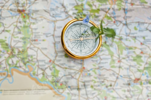 Preview: Close-up photo of compass laying on the map.