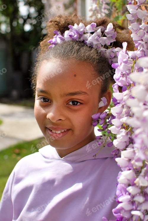 Preview: Portrait of Generation Z girl in front of purple wisteria flowers - petals pink mixed race diversity