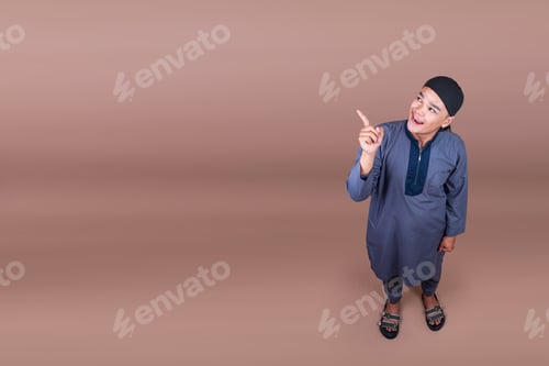 Preview: Overhead Full Length Shot Of Young Muslim Man Looking Up And Pointing Aside To Copy Space