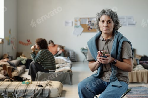 Preview: Mature female refugee having tea in camp