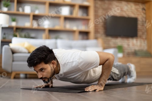 Preview: Strong arabian man doing plank position on yoga mat