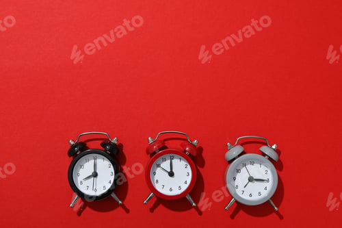 Preview: Classic multi-colored alarm clocks with on a red background