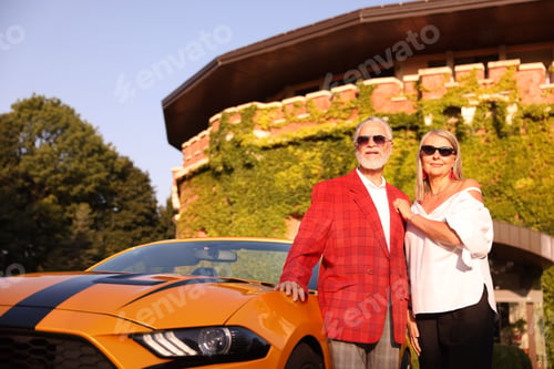 Preview: Stylish senior couple in sunglasses near modern cabriolet outdoors, low angle view