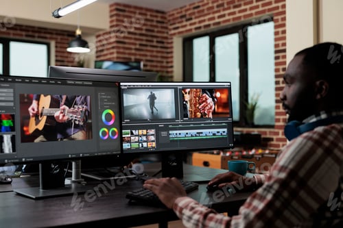 Preview: African american creative digital video editor sitting at desk while improving recorded footage