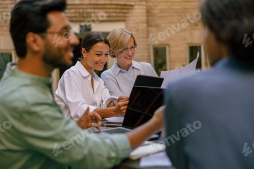 Preview: Creative team collaborating on project during meeting in outdoor cafe. Conception of business