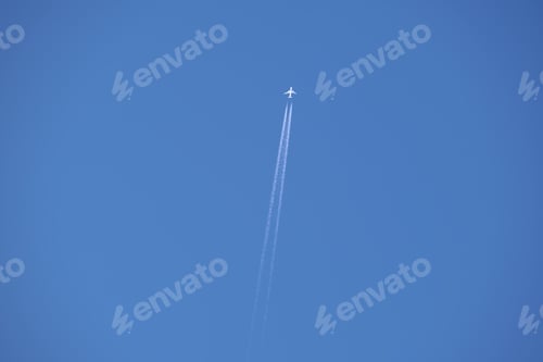 Preview: Distant passenger jet plane flying on high altitude on clear blue sky leaving white smoke