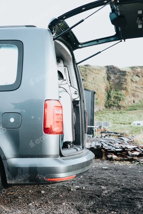 Preview: Caravan van is stand with open doors in front of an iceland mountain during a road trip.Vanlife - li
