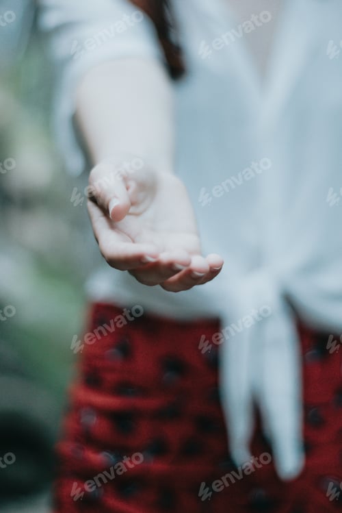 Preview: Woman giving one hand to the camera offering help on a natural parade, light image