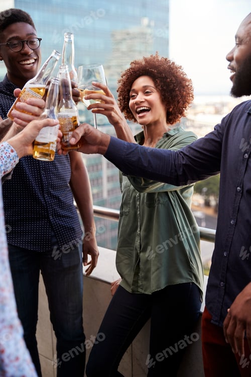 Preview: Smiling creative business colleagues drinking after work raising glasses to make a toast, vertical