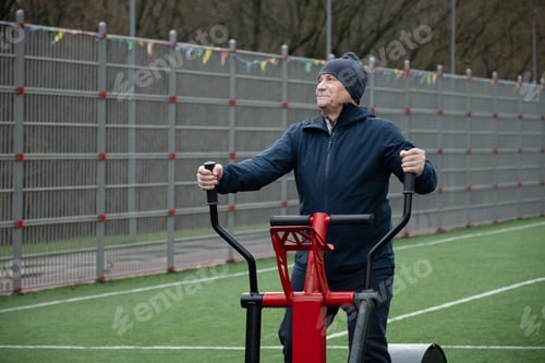 Preview: Senior man resting on outdoor fitness machine. Outdoor Fitness Workout