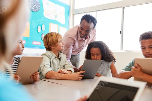 Preview: Teacher among kids with computers in elementary school class