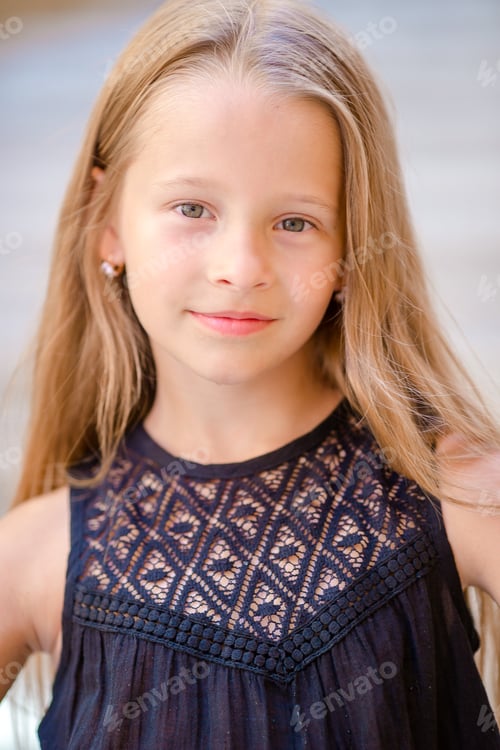 Preview: Adorable happy little girl outdoors in italian city. Portrait of caucasian kid enjoy summer vacation