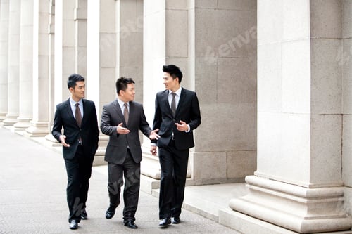 Preview: Cheerful business team walking and talking outside, Hong Kong
