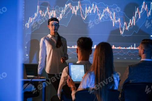Preview: Showing the plan on the projector. Female leader talking to employees in office
