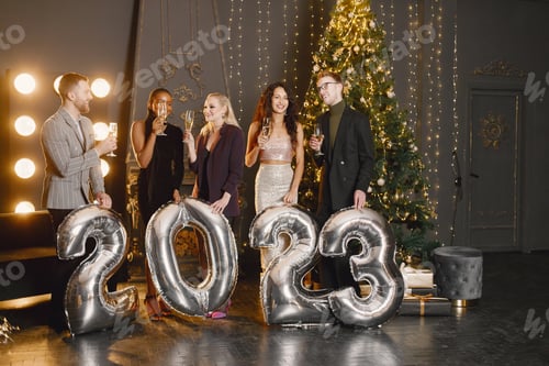 Visualização: Amigos do sexo masculino e feminino em pé com balões 2023 para a celebração do Ano Novo