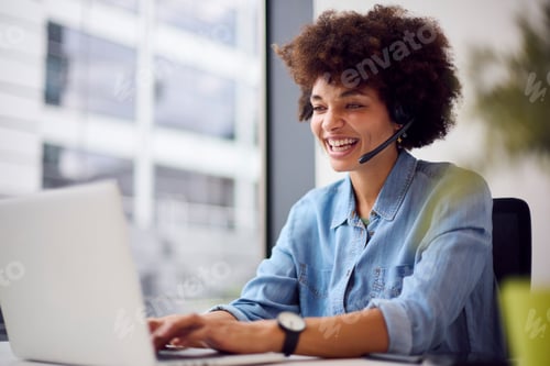 Preview: Young Businesswoman In Modern Office Working On Laptop Using Wireless Headset