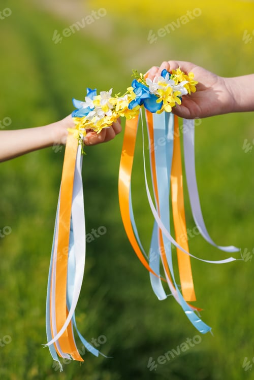 Preview: Close-up on Ukrainian wreath with flowers and ribbons in hands