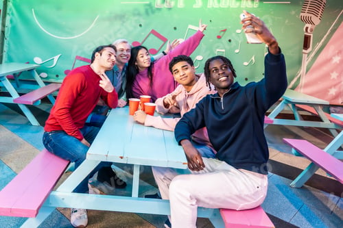 Preview: Multiethnic friends taking selfie at bowling alley cafe