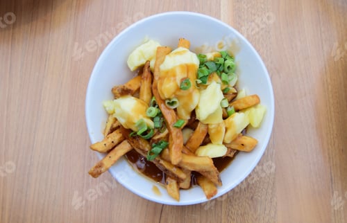 Preview: Poutine, top view of plated cheese curd and gravy over fries, Canada’s famous dish