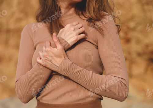 Preview: close-up shot. hands of a young beautiful woman folded on her chest