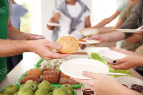 Preview: Volunteers serving food for poor people indoors