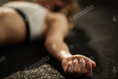 Preview: Close up of exhausted athlete resting on the floor after sports training.