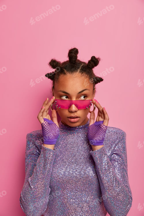 Preview: Beautiful thoughtful woman with dark skin, many buns on head, wears pink sunglasses, fitness gloves
