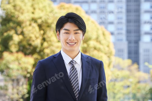 Preview: Japanese male businessman standing in the background of a tree.