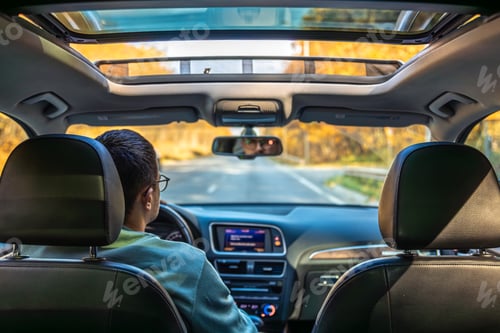 Preview: Driving the modern car on asphalt road. A young man drives a car.