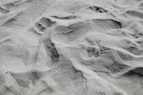 Preview: Grayscale beach shore sand with few rocks in frame