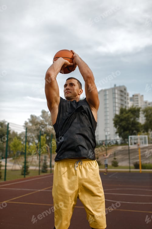 Preview: Basketball player makes a throw on outdoor court