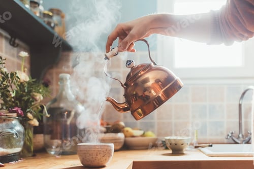 Preview: Arm of man pouring boiling water into bowl in kitchen